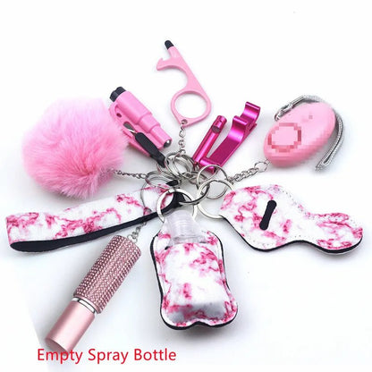 A Kiss Me Later pink and white keychain set with pom-pom, alarms, empty spray bottle, no-touch tool, and beaded lipstick case is displayed on a white background. Text reads: Empty Spray Bottle.