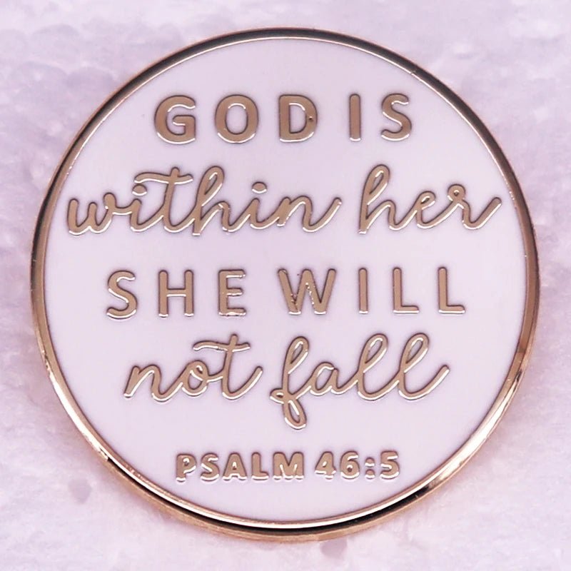 A round white and gold enamel pin with elegant edges, featuring the text: “GOD IS within her SHE WILL not fall PSALM 46:5”—a beautiful faith-inspired accessory.