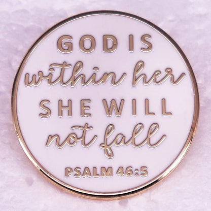 A round white and gold enamel pin with elegant edges, featuring the text: “GOD IS within her SHE WILL not fall PSALM 46:5”—a beautiful faith-inspired accessory.