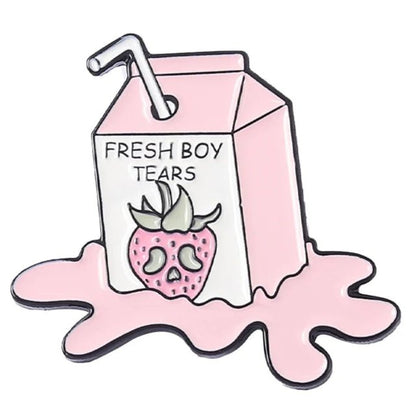 Pink milk carton enamel pin, labeled Fresh Boy Tears, features a sad strawberry in a pink puddle with a straw on top—a quirky accessory with fun, moody vibes.