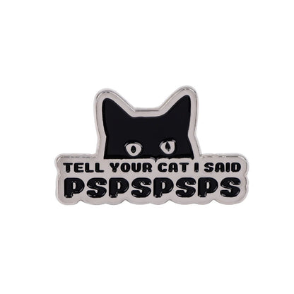 enamel pin featuring a black cats head peeking over a sign with TELL YOUR CAT I SAID pspspsps in bold letters and a tiny red heart detail for extra charm.