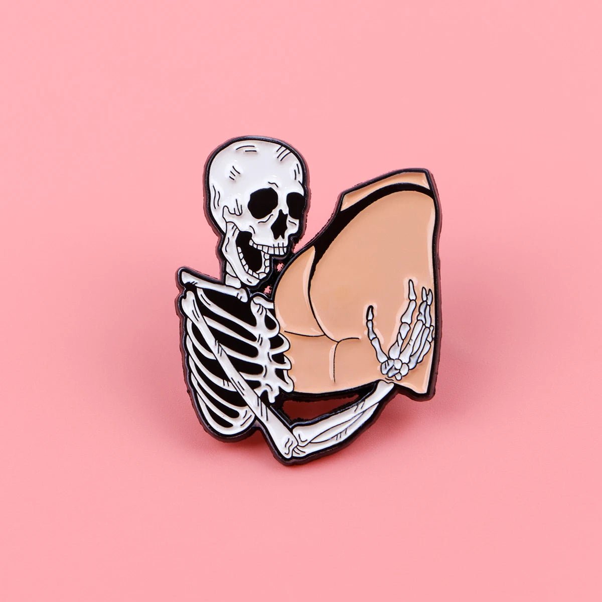 A cartoon skeleton hugs a large, cartoonish human buttock against a pink backdrop—just like a Funny Skeleton enamel pin come to life.