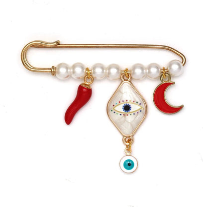 The Kiss Me Later gold evil eye pin with white beads features three hanging charms—a red chili pepper, a blue diamond-shaped evil eye, and a red crescent moon—making it a perfect unique baby shower gift.