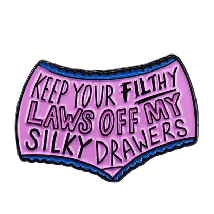 Show off your feminist flair with the My Cutesy Era enamel pin—purple underwear emblazoned with Keep your filthy laws off my silky drawers. A bold accessory for those who know well-behaved women rarely make history.