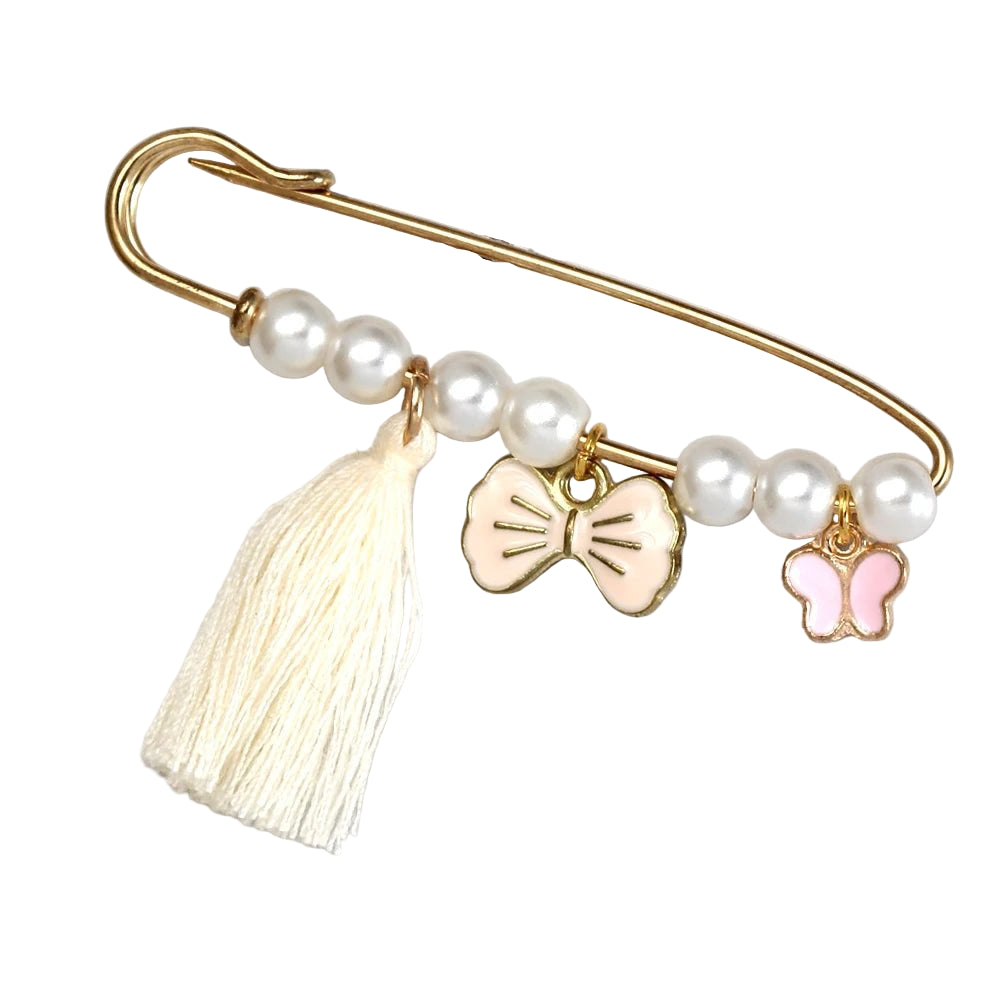 The Kiss Me Later gold evil eye pin features white pearls, a cream tassel, and two charms—a pale pink bow and a pink butterfly. This decorative brooch is perfect as a baby shower gift and comes displayed on a light background.