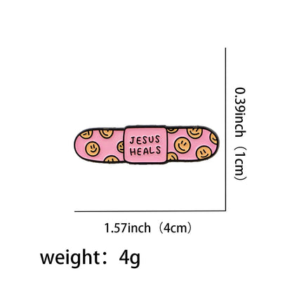 A cute enamel pin shaped like a pink bandaid, with yellow smiley faces and JESUS HEALS in the center. Measures 1.57 x 0.39 (4x1 cm) and weighs 4g.