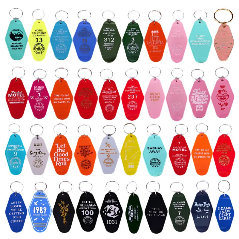 The Kiss Me Later collection features 35 colorful retro hotel key rings, each with unique pop culture-inspired text or graphics, arranged in five rows on a white background.