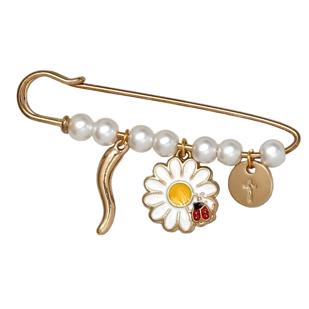 A Kiss Me Later gold safety pin brooch adorned with white pearls, beads, a gold daisy charm featuring a ladybug, and a round gold cross charm—an ideal stylish baby shower gift.