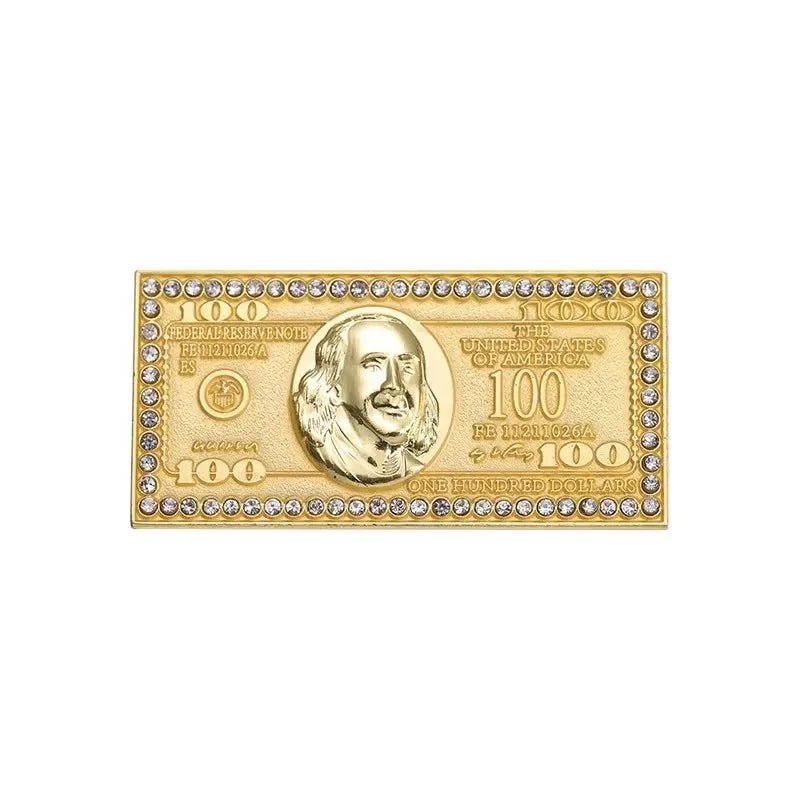 A gold-tone rectangular pin shaped like a $100 bill with a raised portrait, engraved details, and clear rhinestone border—perfect to pair with your favorite Red Lips Cash Roll for a bold statement.
