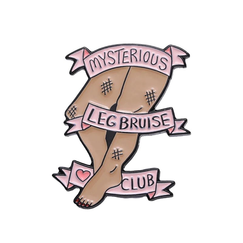 Illustration of crossed legs with small bruises, pink banners reading “Mysterious Leg Bruise Club,” and a love heart—this quirky enamel pin is the perfect self-love accessory.