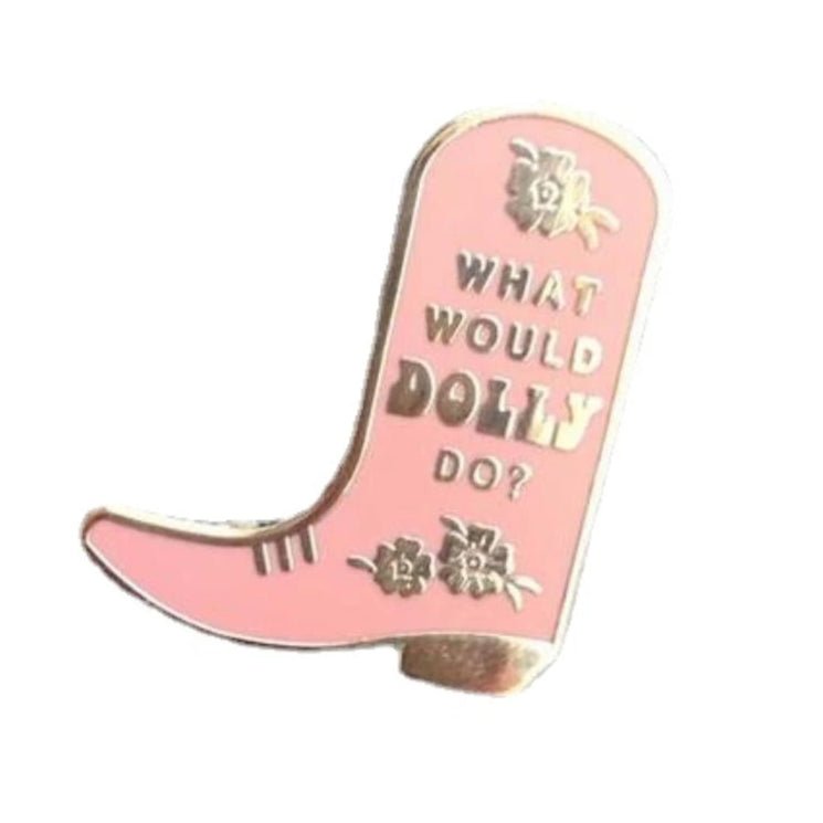 A pink and gold cowboy boot enamel pin by My Cutesy Era, featuring gold details, floral designs, and the phrase WHAT WOULD DOLLY DO?.