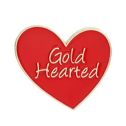 Red and gold heart-shaped enamel pin features gold trim and the words Gold Hearted elegantly written in gold on the front.