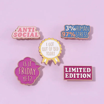 Five colorful enamel pins — including a red love heart, Cute But Psycho, ANTI SOCIAL, 3% HUMAN 97% STRESS, and LIMITED EDITION—rest on a light purple background.