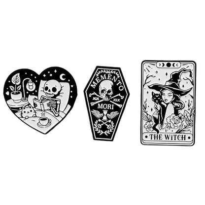 Kiss Me Later: three black-and-white spooky illustrations—a skeleton drinking tea in a heart, a “Memento Mori” coffin with skull, and a tarot-style witch with hat and flowers labeled The Witch.