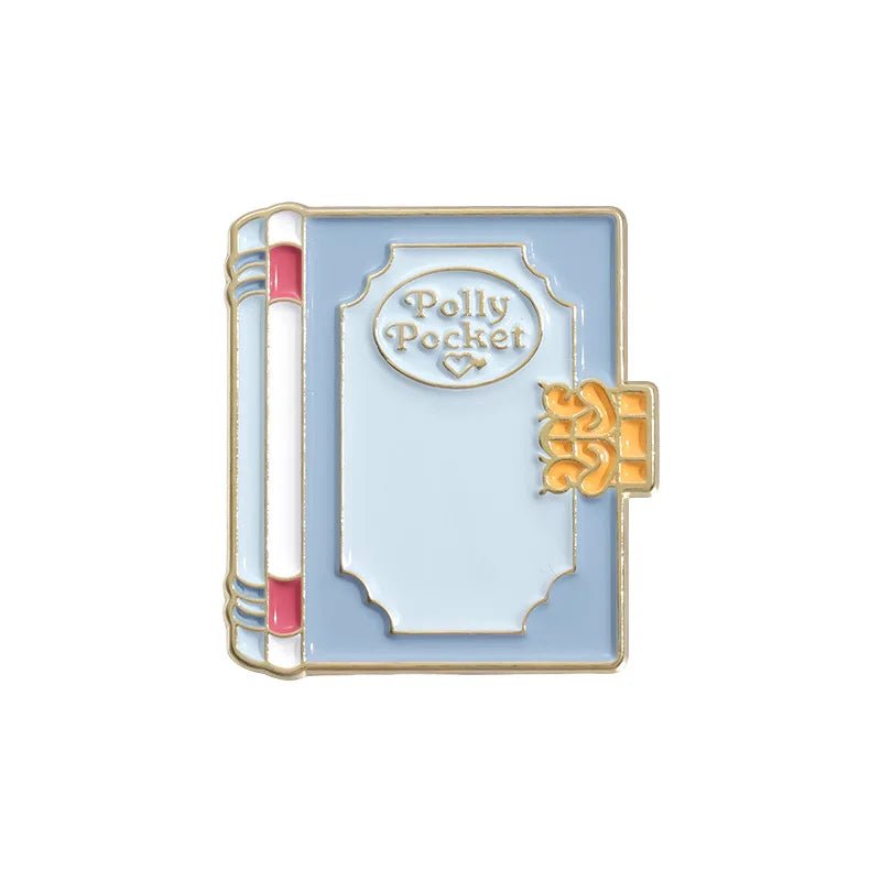 A blue and white enamel book pin by My Cutesy Era with "Polly Pocket" on the cover, gold accents, a pink spine stripe, and a decorative clasp—an adorable gift or accessory for book lovers.