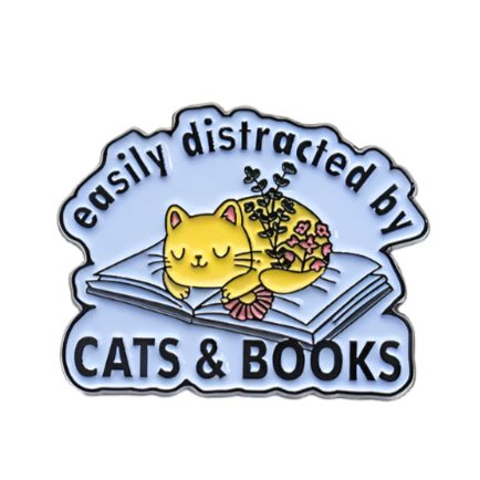 A cute yellow cat with flowers naps on an open book, with "Easily distracted by CATS & BOOKS" in playful black letters. My Cutesy Era's purrfect pick for book lovers and bookworm gifts!.