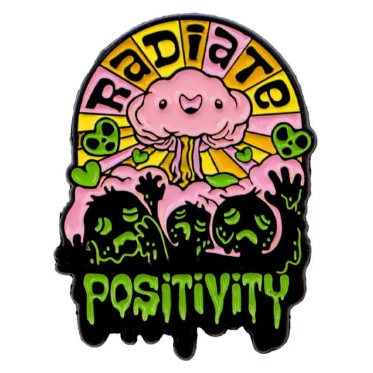 A vibrant enamel pin featuring a smiling pink mushroom cloud, yellow sun rays, and “Radiate Positivity.” Green slime shapes and hearts accent the base, with “Positivity” in dripping green letters.