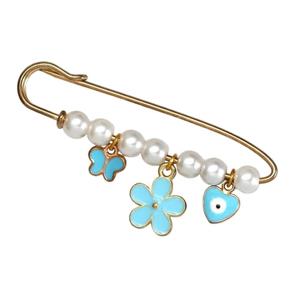 The Kiss Me Later gold safety evil eye pin features five white pearls and three blue charms—a butterfly, flower, and heart with a black dot—making an adorable brooch, perfect as a baby shower gift.
