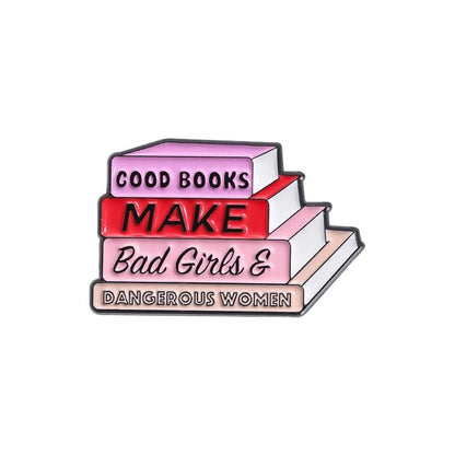 A charming enamel pin features a stack of pastel-colored books with spines reading: GOOD BOOKS, MAKE, Bad Girls &, and DANGEROUS WOMEN in bold and cursive text.