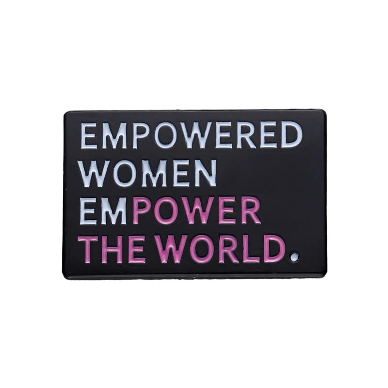 A rectangular black enamel pin features “Empowered women empower the world” in white and pink capitals—a bold statement piece for any feminist pin collection.