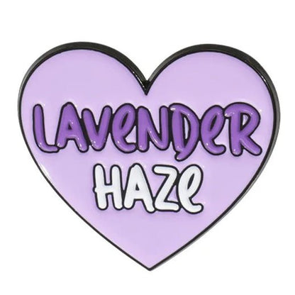 A heart-shaped enamel pin with a light purple background, featuring Lavender Haze in bold letters—Lavender in dark purple and Haze in white.