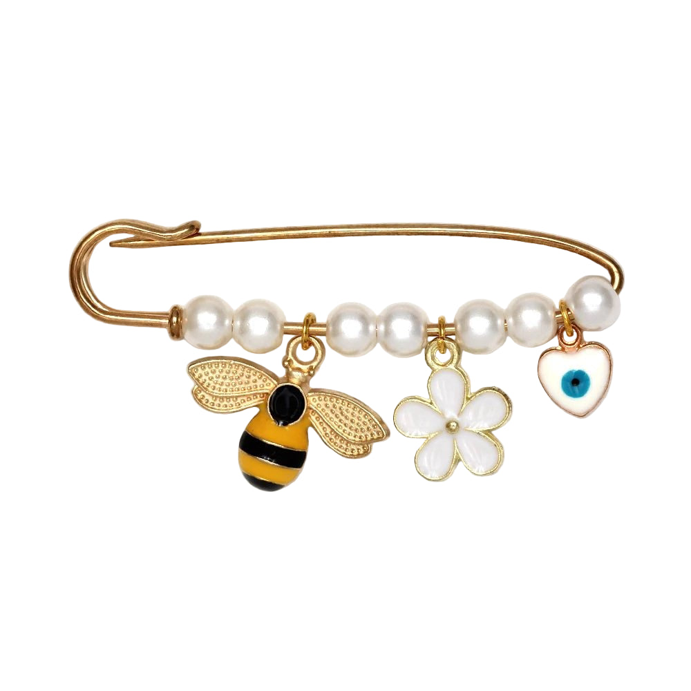 The Kiss Me Later gold safety pin features pearl-like beads and three charms—a gold and black bee, a white flower, and a white heart with a blue evil eye—making it a lovely brooch or thoughtful baby shower gift.
