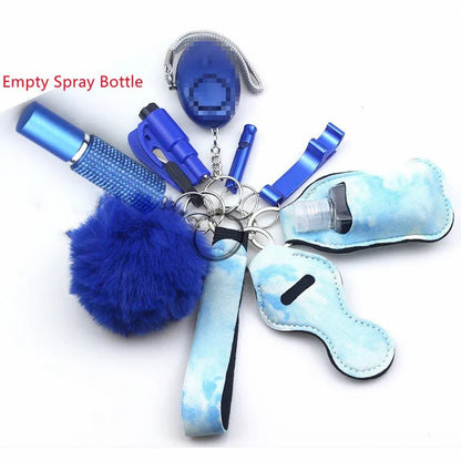 The Kiss Me Later blue keychain set features self-defense and safety accessories—spray bottle, fluffy pom-pom, whistle, alarm, and sanitizer holder—arranged in a circle on white, ideal for outdoor adventures.
