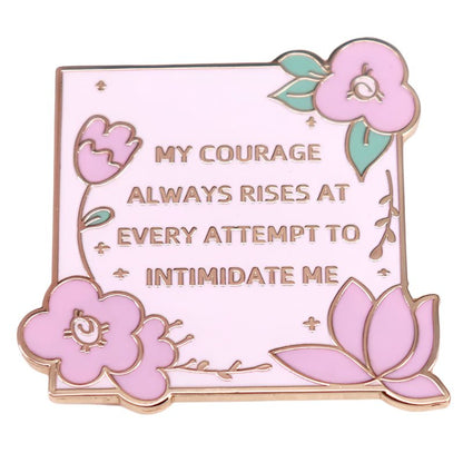 A pink enamel pin by My Cutesy Era featuring Jane Austen, floral accents, green leaves, and the quote: My courage always rises at every attempt to intimidate me.
