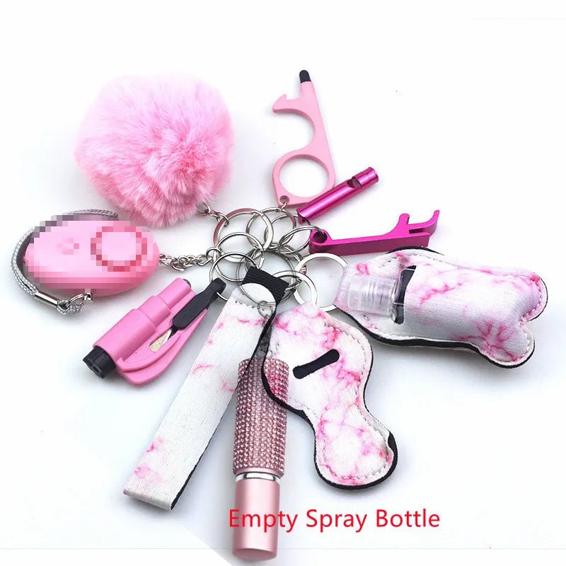 The Kiss Me Later pink and white keychain set includes a fluffy pom-pom, safety alarm, sanitizer holder, whistle, touch tool, lip balm holder, and an empty spray bottle—ideal for outdoor adventures.