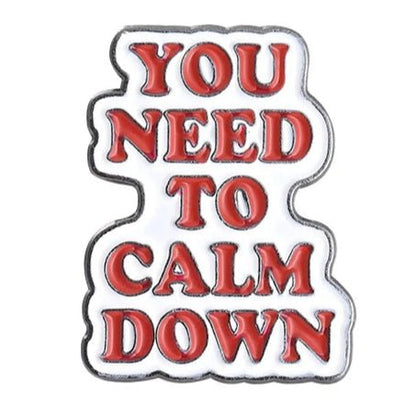 Metallic badge with 'You Need to Calm Down' in red text on a white background