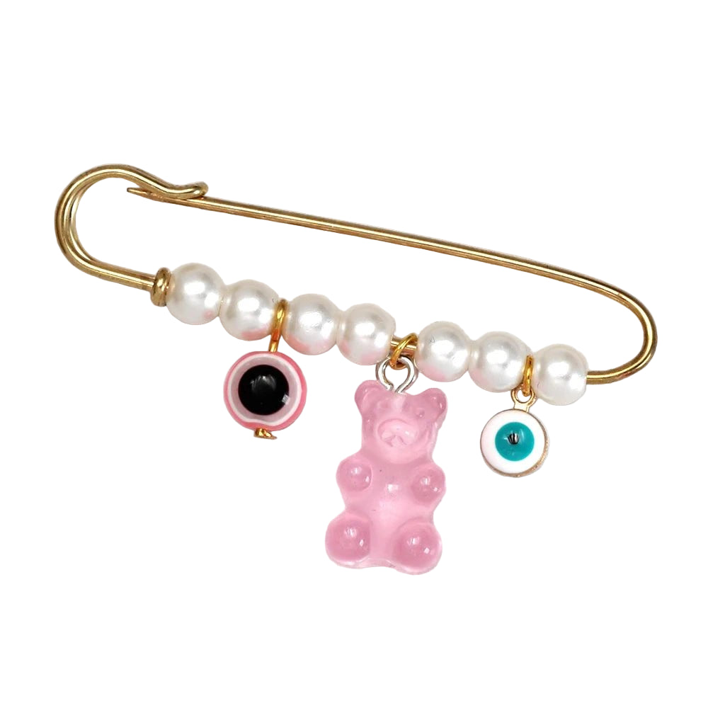 Kiss Me Later’s gold safety pin brooch with white pearls features three cute charms—a pink and black evil eye, a pink gummy bear, and a blue and white eye—making it an adorable baby shower gift.
