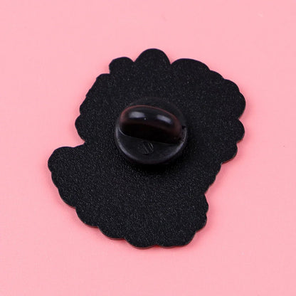 A wavy-edged black enamel pin backing with a rubber clutch from Gay Skate rests on a pink background—a perfect addition to your pride accessories collection.