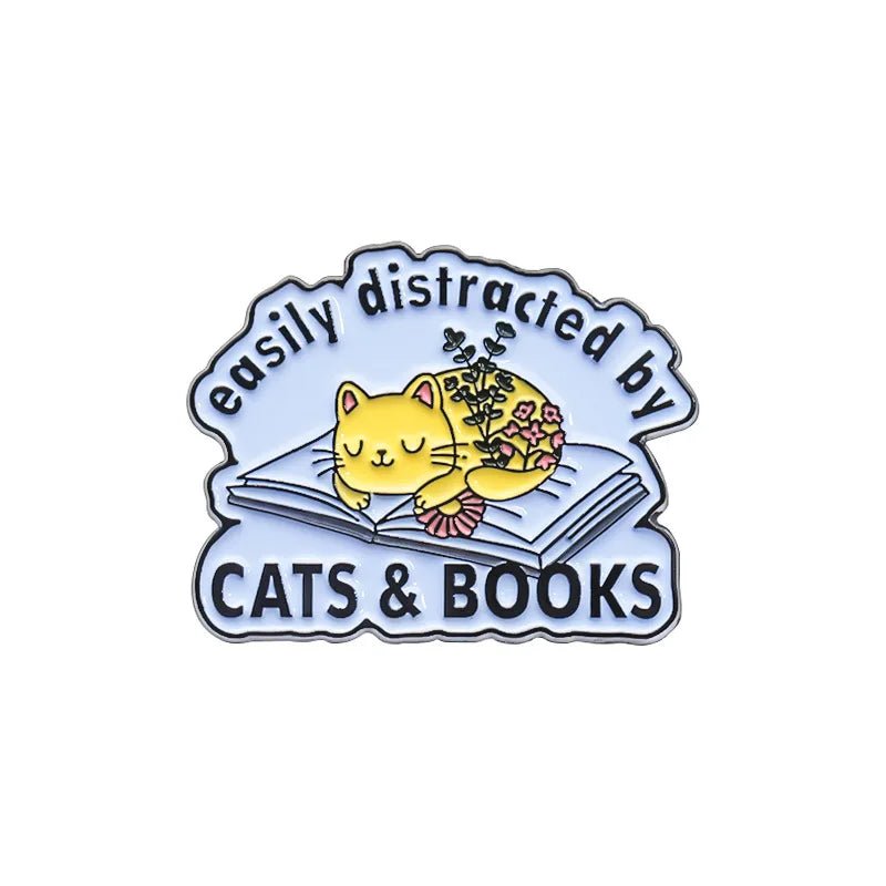 My Cutesy Era’s book pin shows a yellow cat napping on an open book beside a potted plant. With “easily distracted by CATS & BOOKS” text, it’s a perfect gift or accessory for book lovers and bookworms.