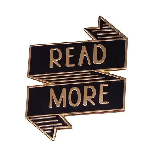 The My Cutesy Era black enamel ribbon pin features a gold outline and READ MORE in gold lettering with arrows at each end—perfect for enamel pin collectors and book lovers.