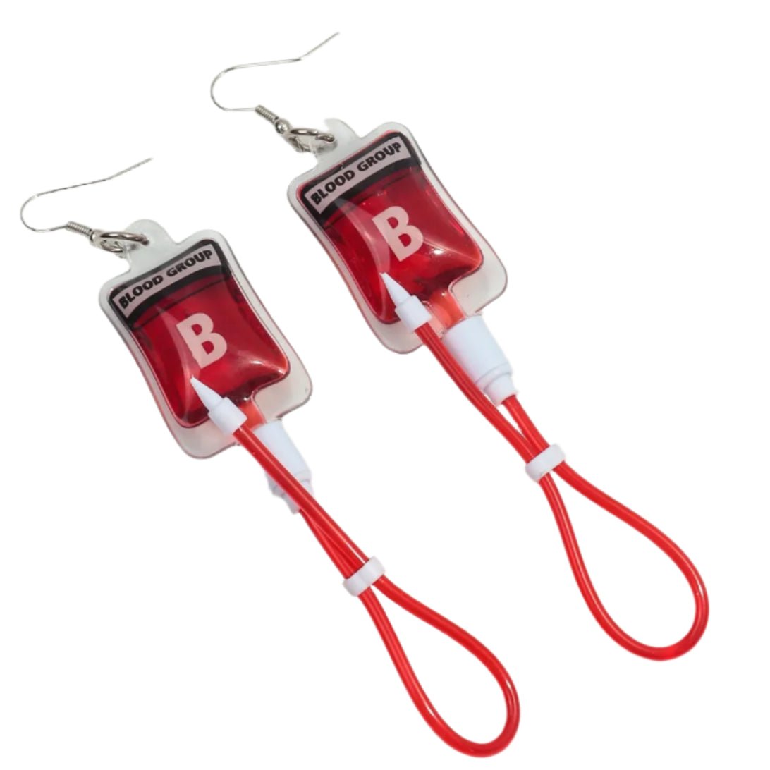 Kiss Me Later presents blood bag earrings shaped like blood group B bags, with red tubing, clear plastic, and metal hooks—ideal for nurses or anyone wanting a quirky gothic accessory.