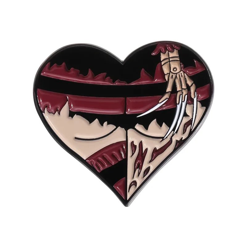 Heart-shaped enamel pin channels Freddy Krueger with Gothic flair—a red and black striped sweater, beige skin, bloody wounds, fishnet accents, and a glove with razor claws.