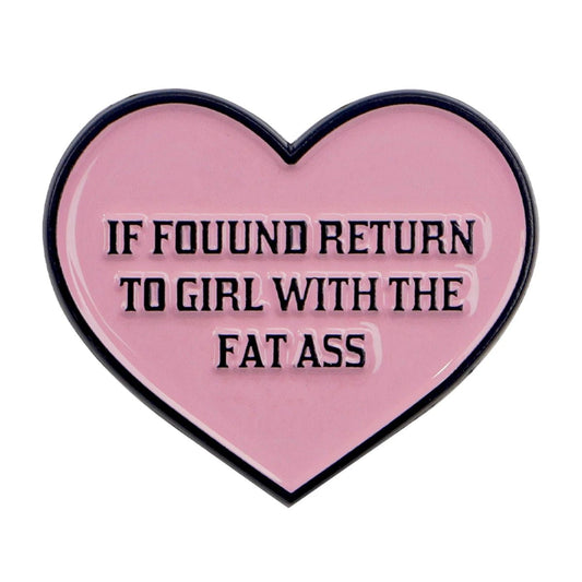 A playful Kiss Me Later enamel pin: pink love heart with black trim and bold “IF FOUND RETURN TO GIRL WITH THE FAT ASS” text—perfect novelty accessory to make a cheeky statement.