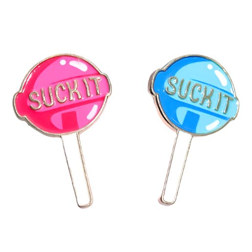 Two lollipop enamel pins by My Cutesy Era—one pink, one blue—with “SUCK IT” in bold on each candy, metallic outlines and sticks.