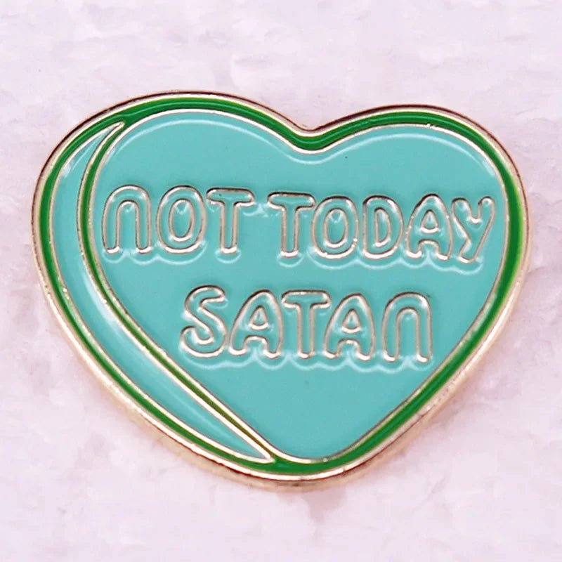 Enamel pin that is mint green and heart-shaped, with NOT TODAY SATAN in white letters, a thin gold outline, and a light textured background. Reminiscent of pink love heart pins.