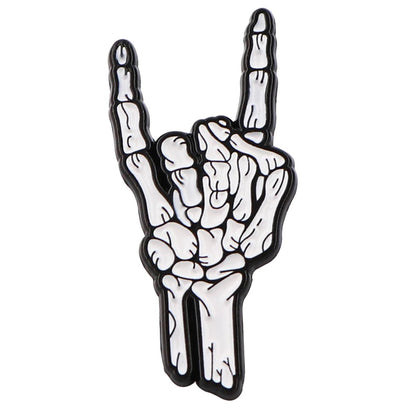 The Kiss Me Later enamel pin features a white skeleton hand making the rock on gesture, with raised index and little fingers for ultimate spooky vibes.