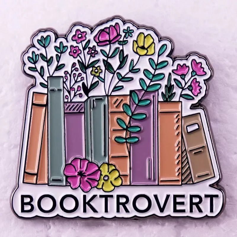 Floral enamel pin to your collection—features books with blooming flowers above “BOOKTROVERT” in bold. Ideal for Romance Readers or book lovers, this colorful badge has a soft, lightly textured background.