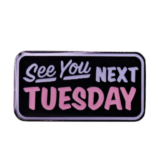 Rectangular badge has a black background with white and pink “See You Next Tuesday” text in mixed fonts—a cheeky nod to the C U N T acronym.