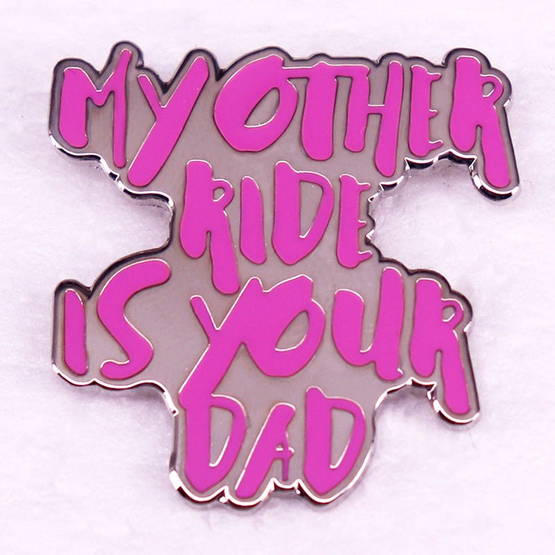 A humorous enamel pin with hot pink MY OTHER RIDE IS YOUR DAD text in a bold, playful font on white.
