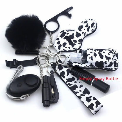 The Kiss Me Later keychain set includes a black fluffy pom-pom, whistle, alarm, self-defense tools, and spray bottle—some with trendy white and black cow prints—perfect for outdoor adventures and personal safety.