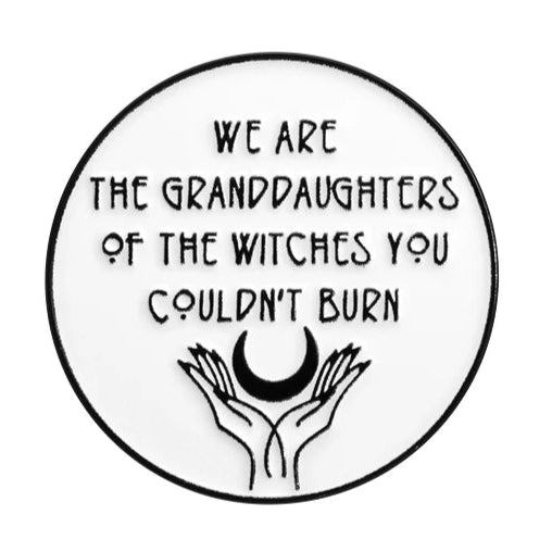 A round enamel pin by My Cutesy Era features “We are the granddaughters of the witches you couldn’t burn” above two hands holding a crescent moon—a bold feminist symbol celebrating strong women.