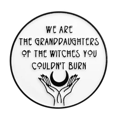 A round enamel pin by My Cutesy Era features “We are the granddaughters of the witches you couldn’t burn” above two hands holding a crescent moon—a bold feminist symbol celebrating strong women.
