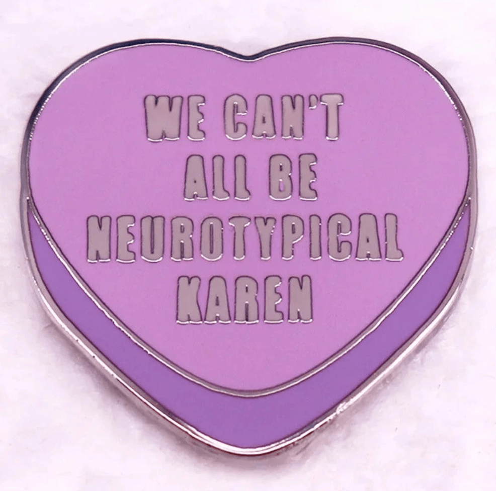 Lavender heart-shaped enamel pin features silver trim and the words WE CANT ALL BE NEUROTYPICAL KAREN. Perfect for LGBTIQ pride, it comes displayed on a soft white background.