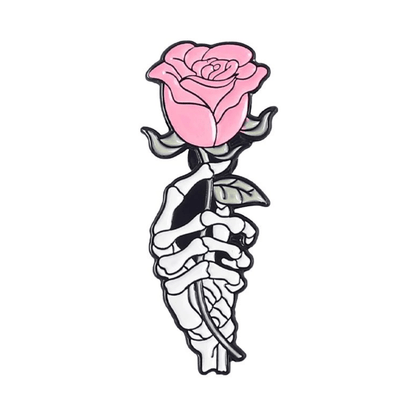 A skeleton hand holds a pink rose with green leaves on a white background—an ideal enamel pin design 