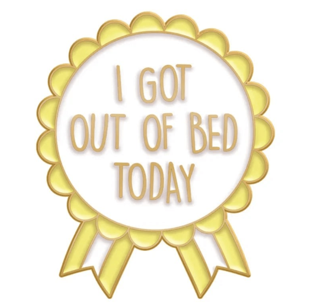 A yellow award ribbon badge with I GOT OUT OF BED TODAY in gold letters—perfect to pair with your Cute But Psycho enamel pin. Ships worldwide.