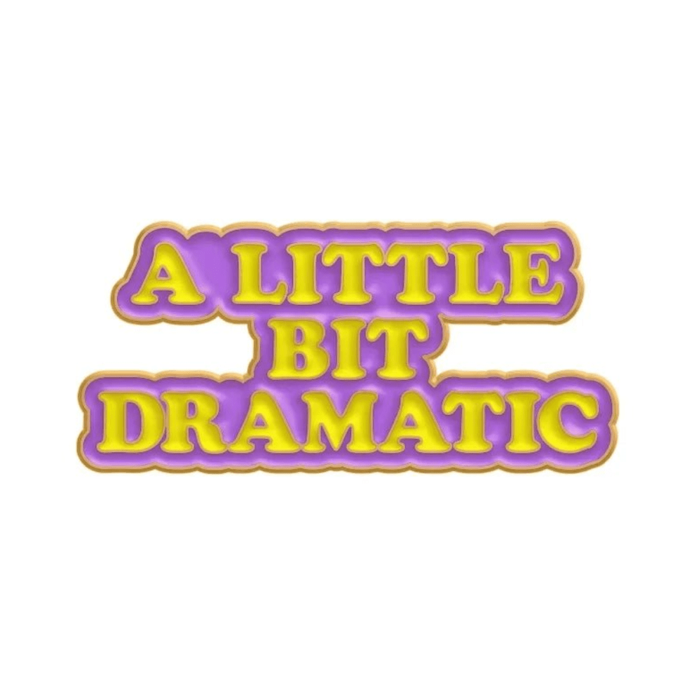 Bold yellow A LITTLE BIT DRAMATIC text on purple with a gold outline set on white—great match for your Cute But Psycho enamel pin. Ships worldwide!.